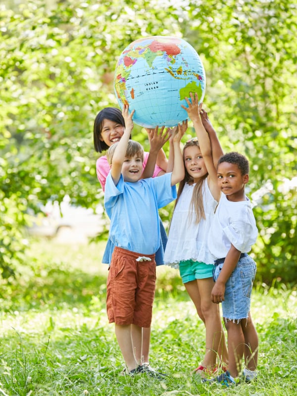 children outdoors, holding an Earth Globe