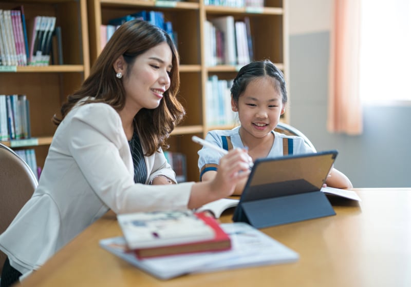 female teacher tutoring a girl